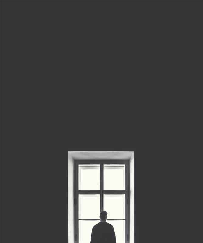 Person looking out of a round window, seeking relief